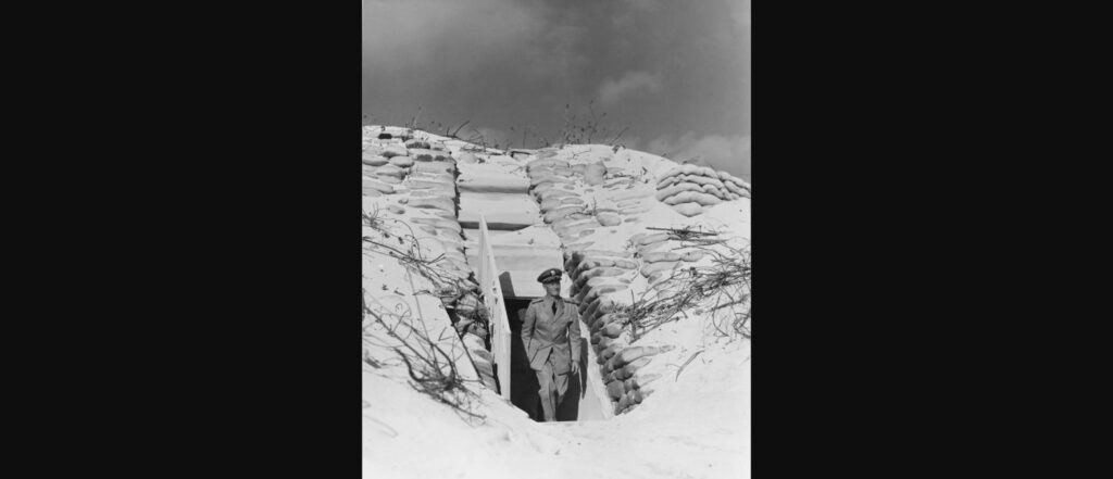 Admiral Chester W. Nimitz walking out of a sandbagged bunker on Midway Atoll, 1942