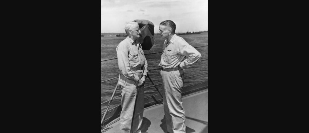 Admiral Chester W. Nimitz and Admiral William F. Halsey standing face to face in conversation on the deck of USS Curtiss, 1943
